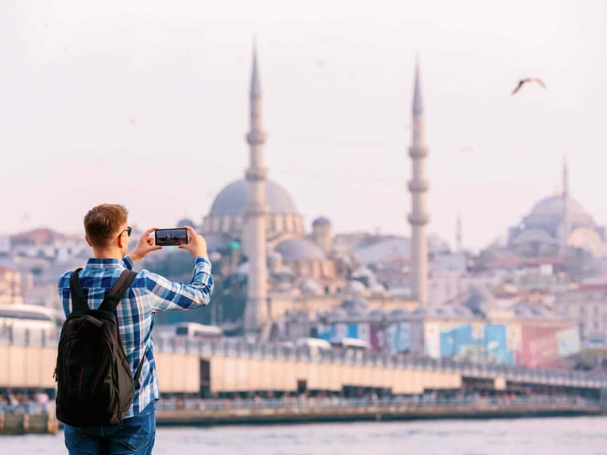 A picture of a tourist photographing the Blue Mosque in Turkiye