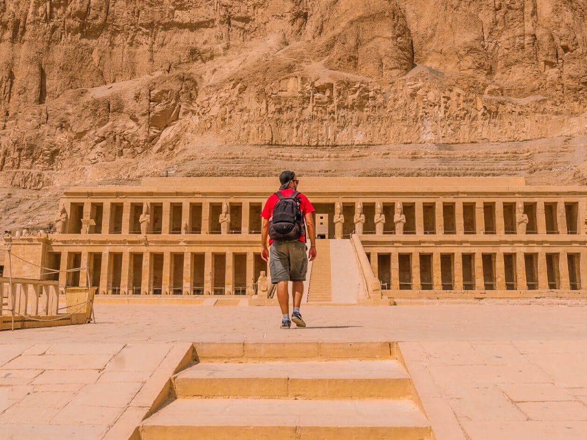 A picture of a visitor in front of the Temple of Hatshepsut
