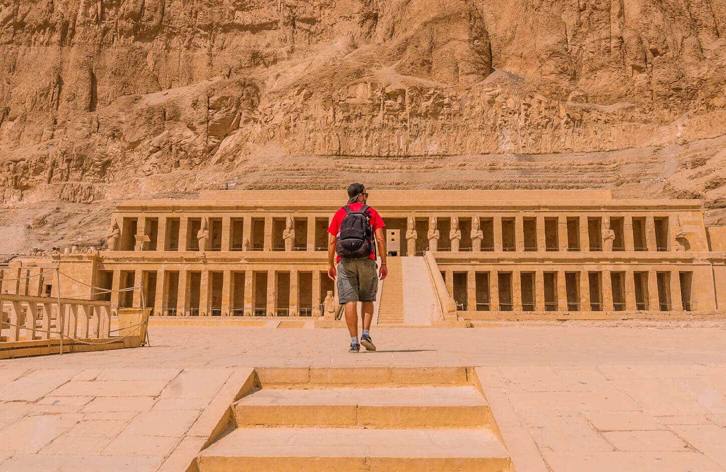 A picture of a visitor in front of the Temple of Hatshepsut