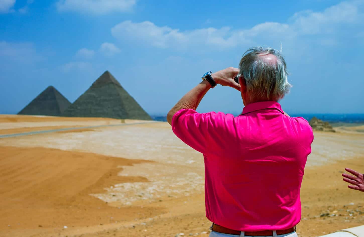 A picture of a visitor photographing the Great Pyramids of Giza