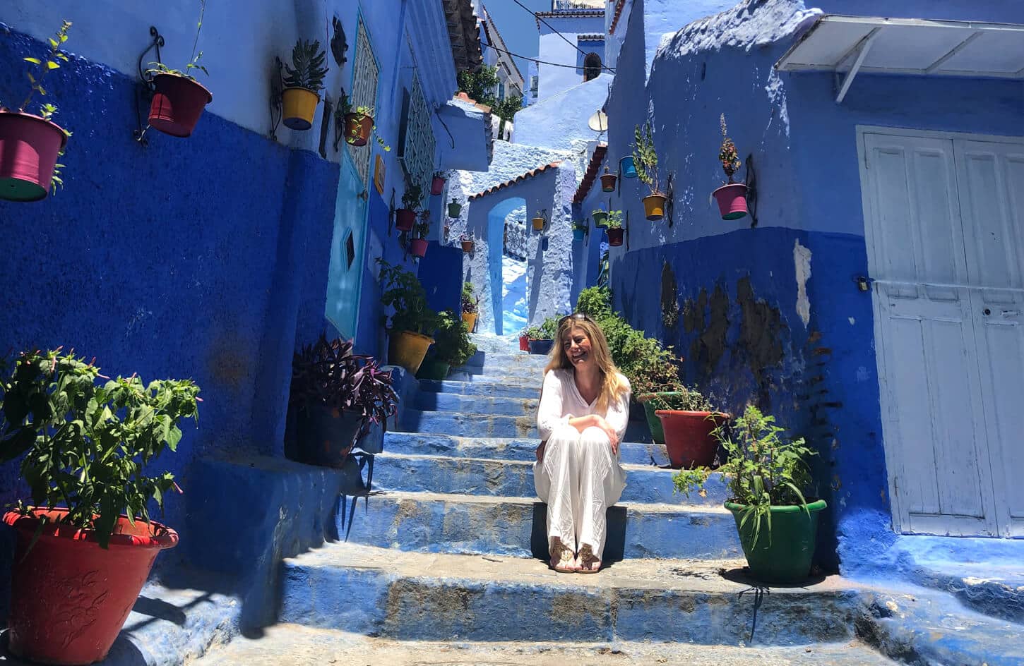 A wonderful picture of a woman smiling on a trip to the blue city of Chefchaouen