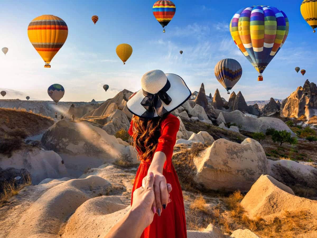 A wonderful shot of a tourist in Cappadocia Turkey with hot air balloons