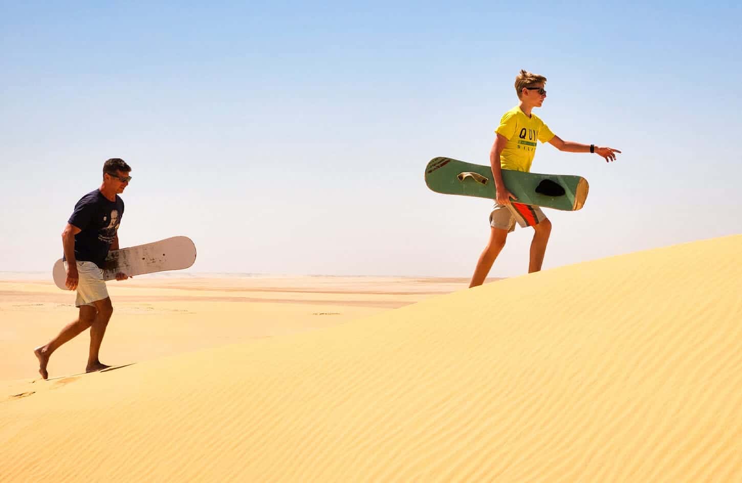 A wonderful shot of father and son while practicing sandboarding in Fayoum