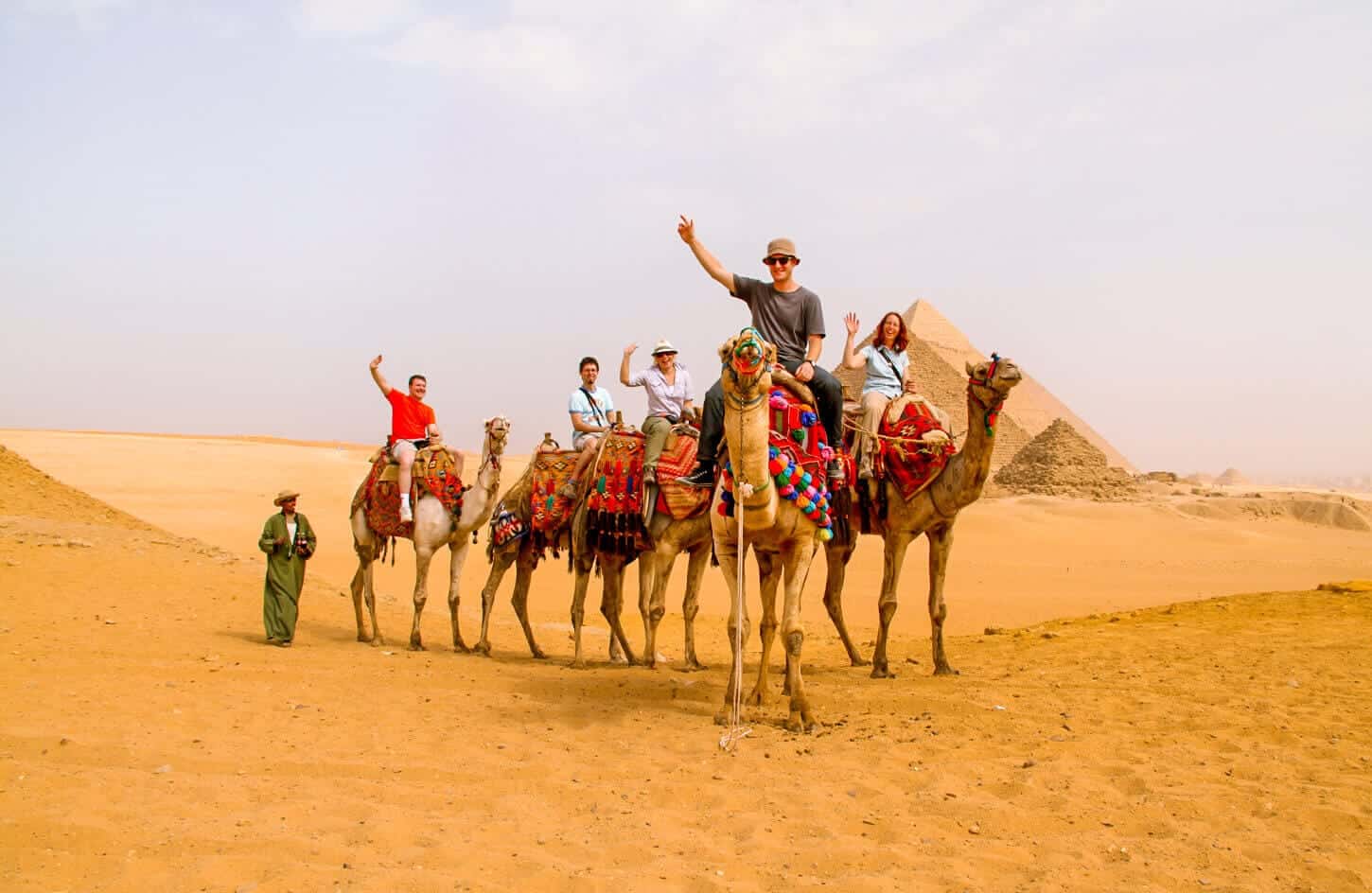 Pictures of some tourists riding camels in the pyramids area