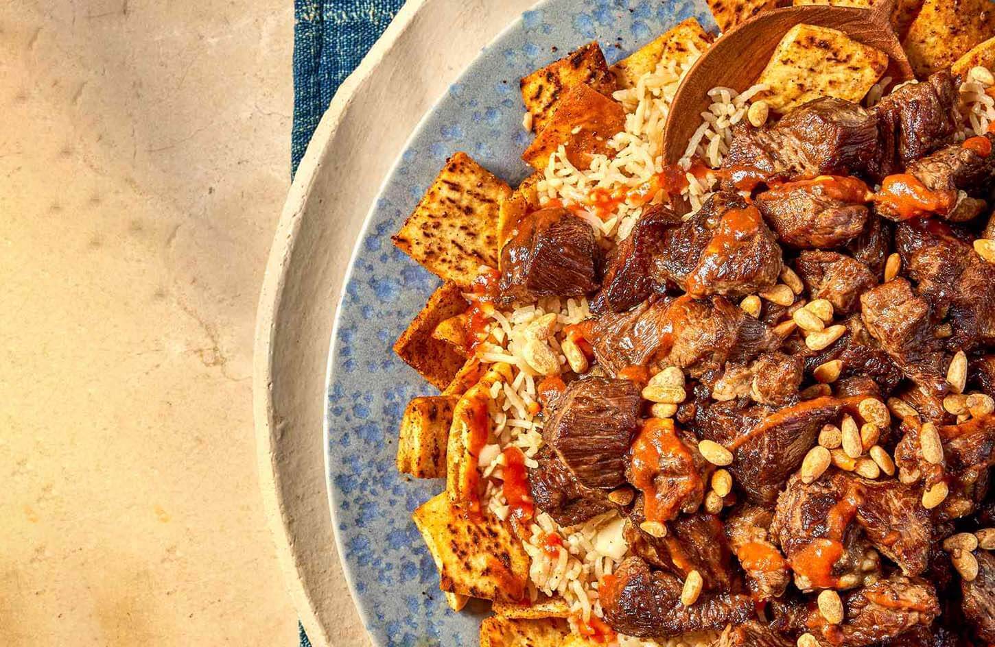 Egyptian fattah celebratory dish with rice, lamb, bread layers, and garlic vinegar tomato sauce