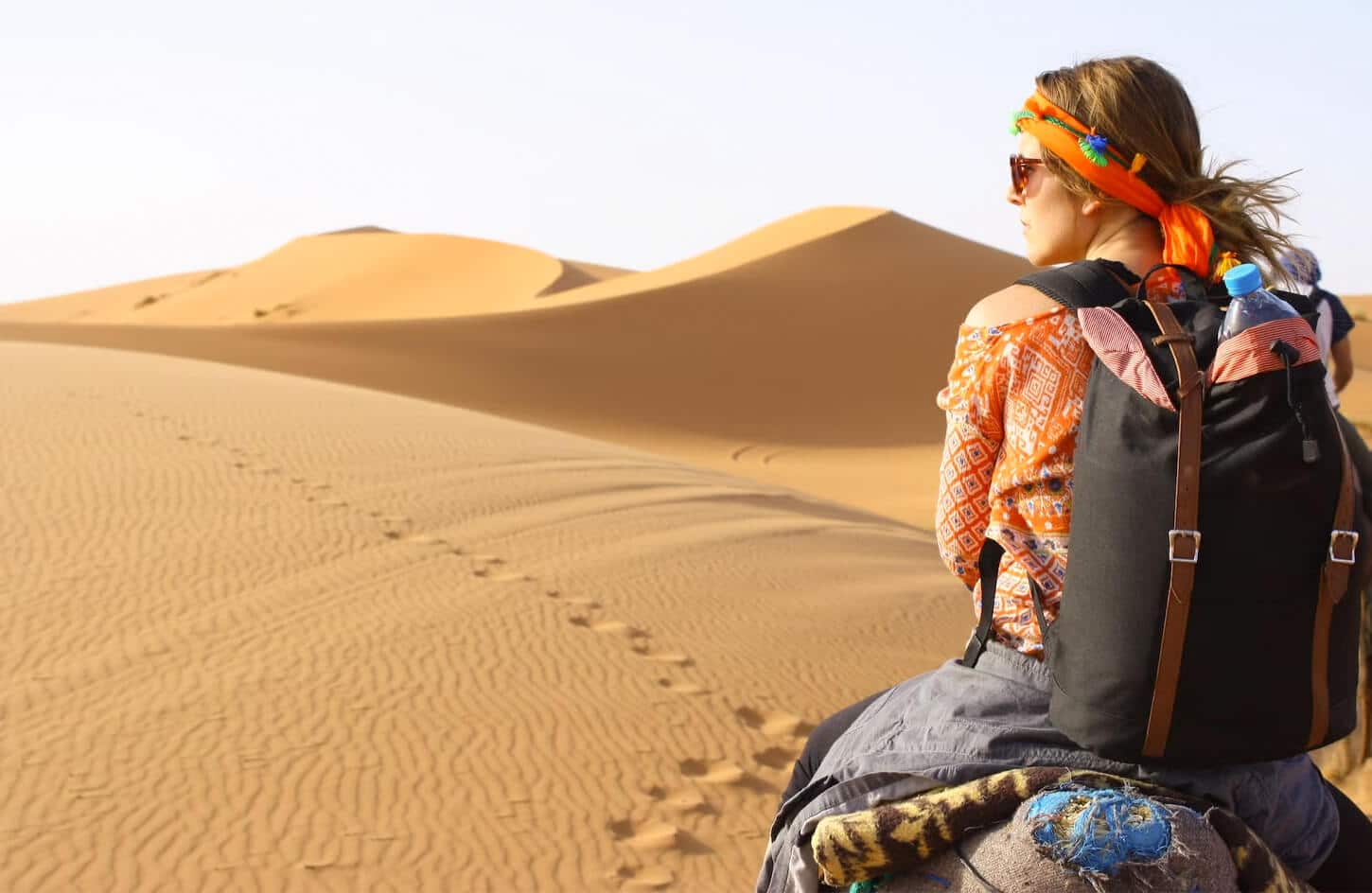 A wonderful photo of a solo female traveler in the Arabian Desert
