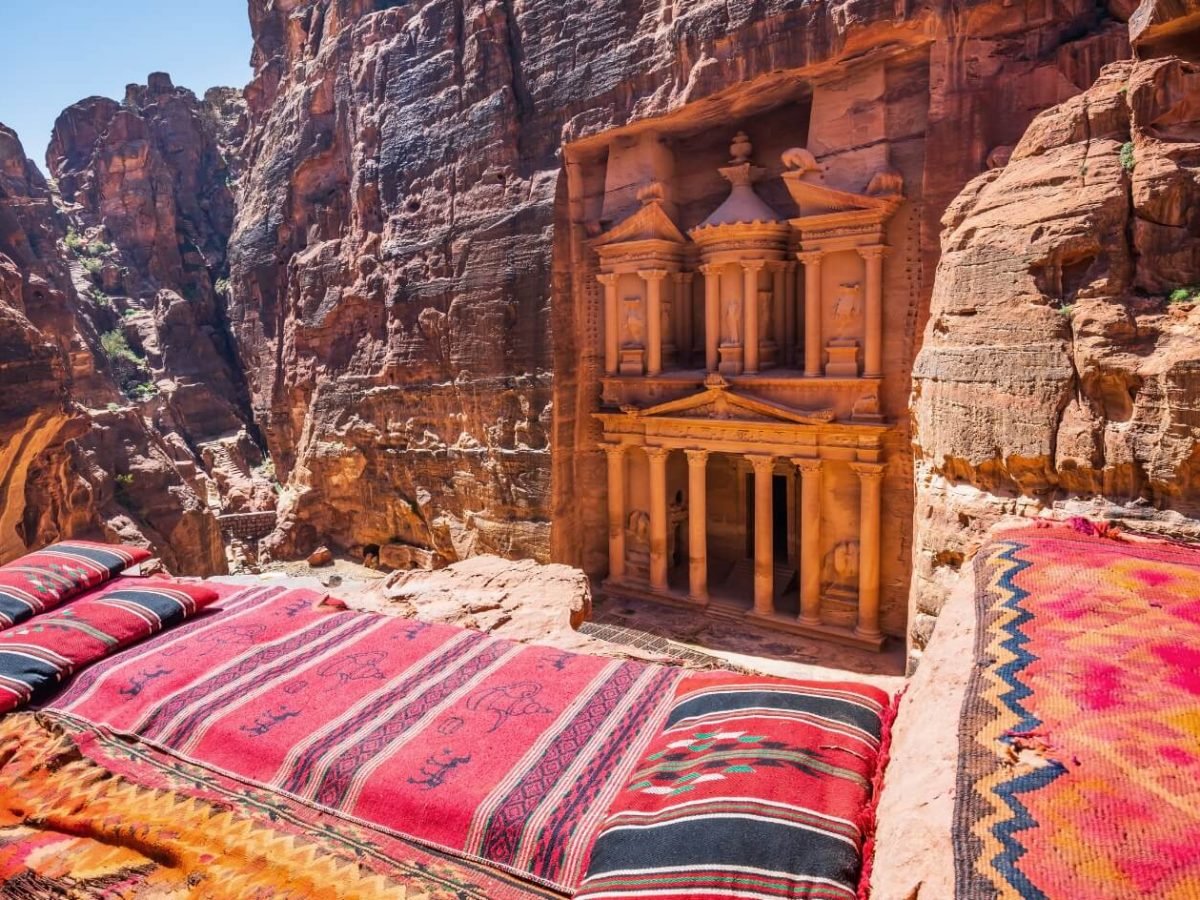 a distinctive shot of the facade of the magnificent temple of petra and sitting in front of it