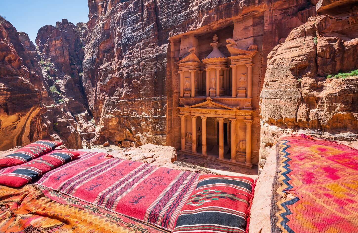a distinctive shot of the facade of the magnificent temple of petra and sitting in front of it