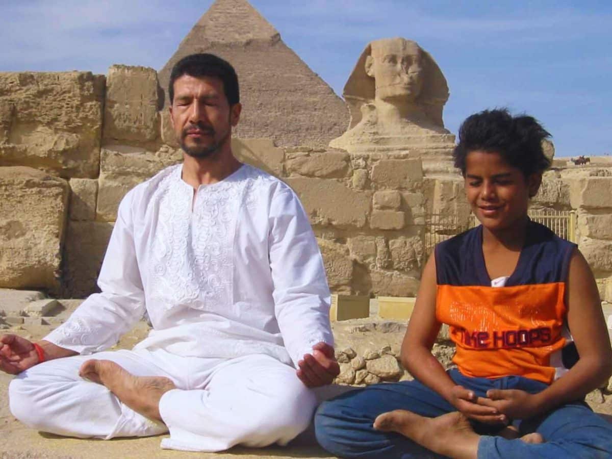 a wonderful shot of a father and his son relaxing in front of the giza pyramids