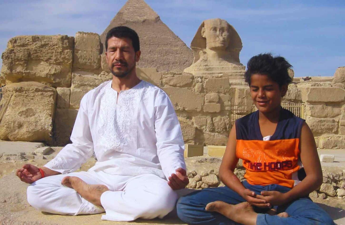 a wonderful shot of a father and his son relaxing in front of the giza pyramids