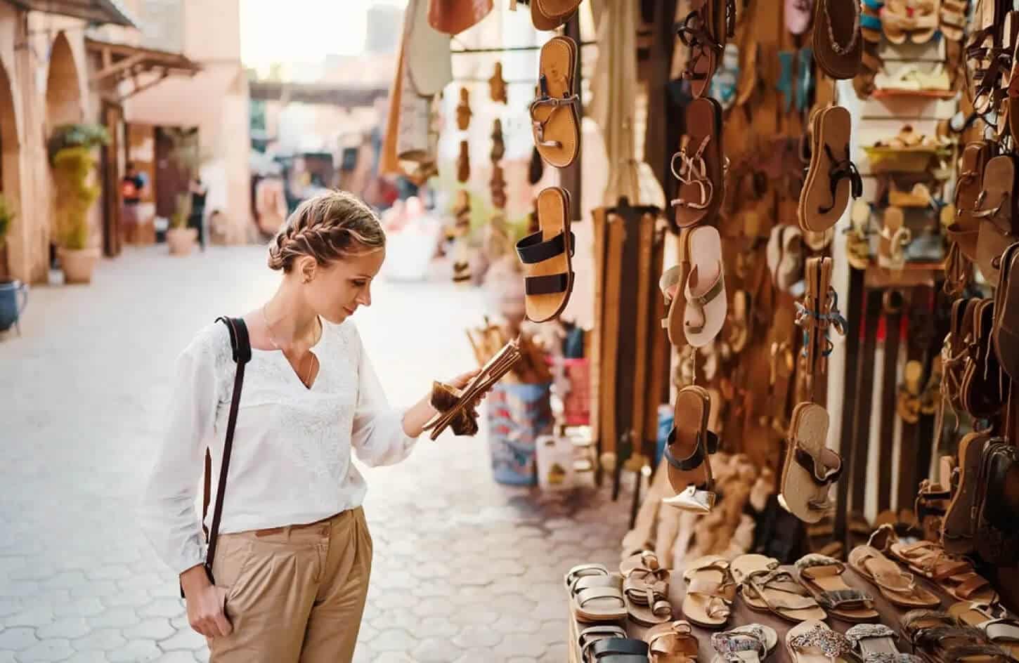 A wonderful photo of a tourist buying shoes in the market