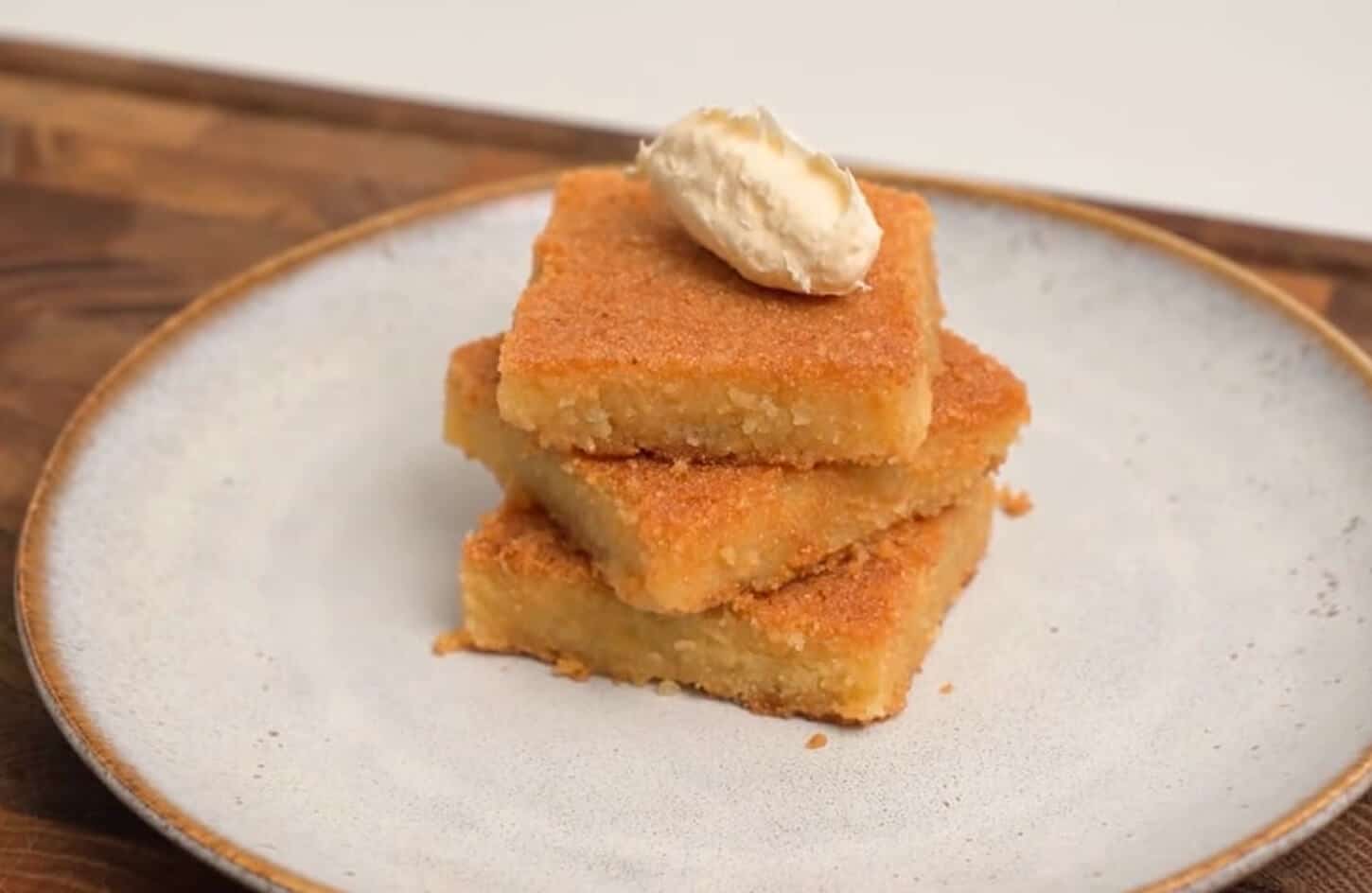 Egyptian basbousa semolina cake soaked in sugar syrup with almond topping on a white plate