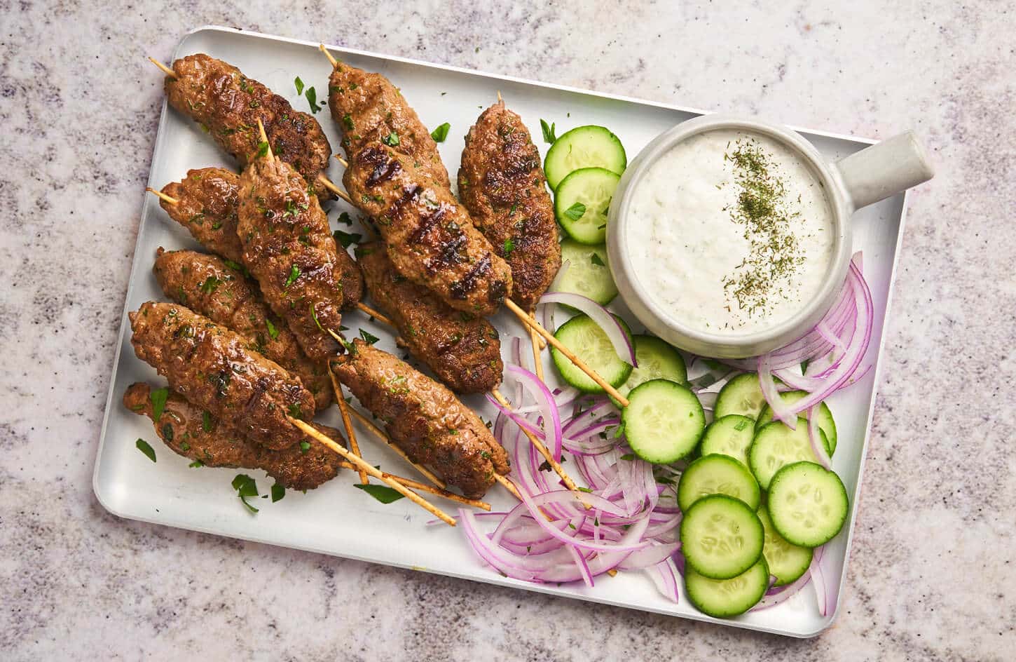 Egyptian kofta and kebab skewers grilled over charcoal served with pita bread and tahini