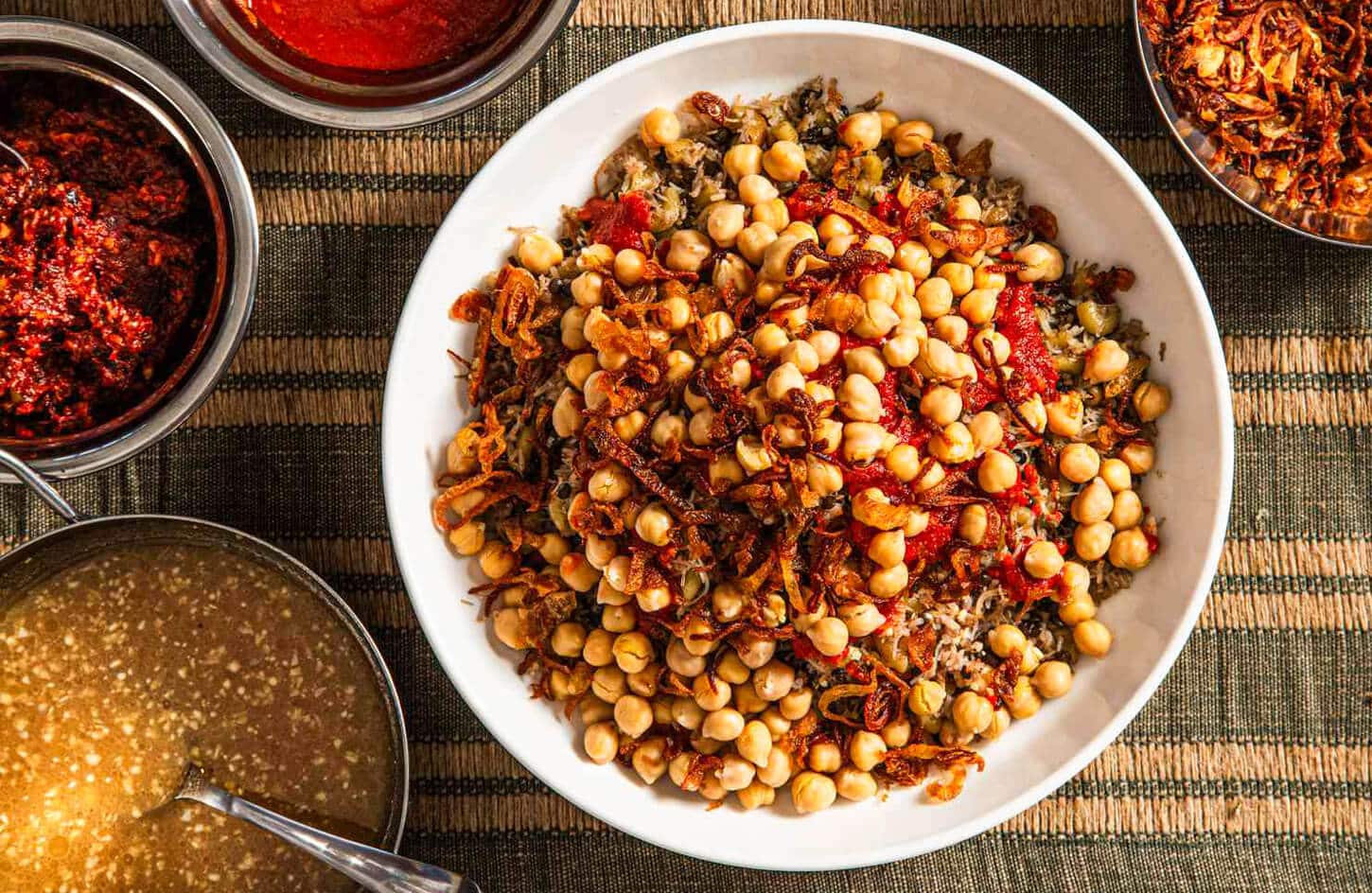 Egyptian koshari national dish with rice, lentils, pasta, chickpeas, and tomato sauce in a bowl