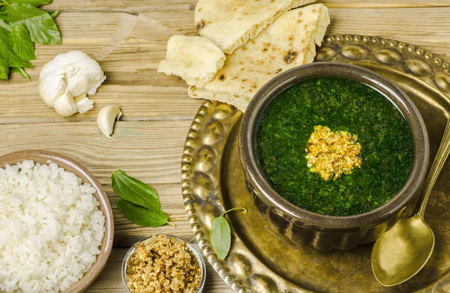 Bowl of Egyptian mulukhiya jute leaf soup with chicken and rice, traditional Egyptian stew