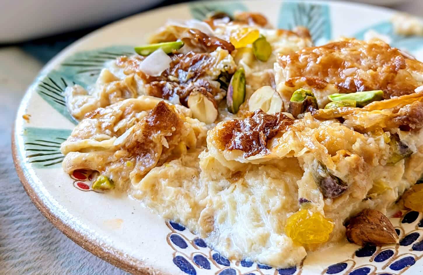 Egyptian umm ali warm bread pudding with mixed nuts, coconut, and golden baked crust