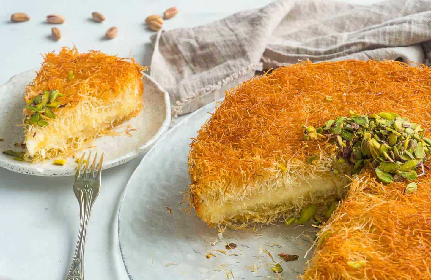 Egyptian kanafeh kunafa dessert with shredded pastry, cheese filling, and crushed pistachios