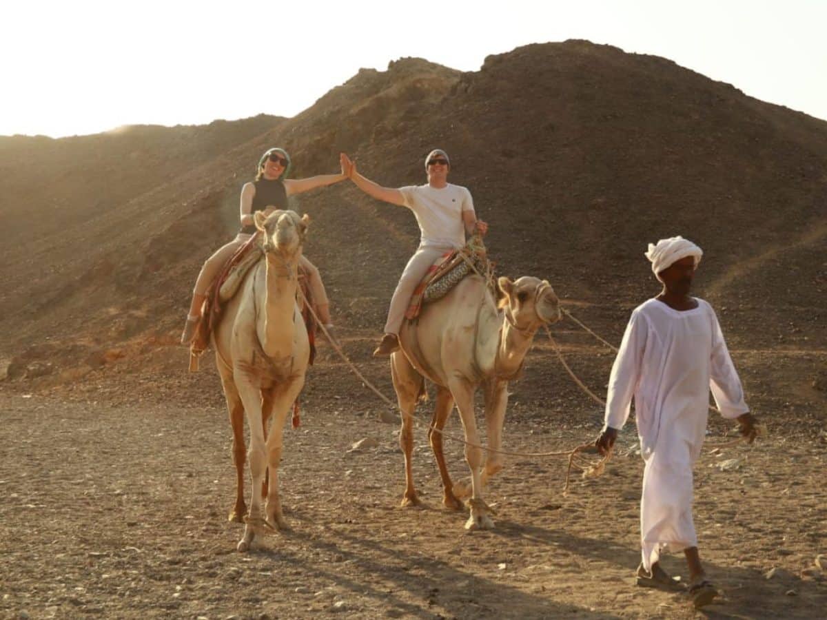 a distinctive shot of a couple riding camels in marsa alam