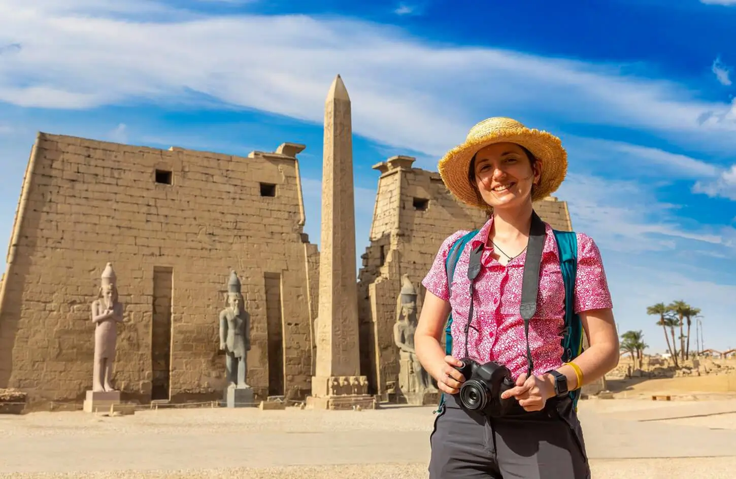 Female tourist posing at the entrance of Luxor Temple.