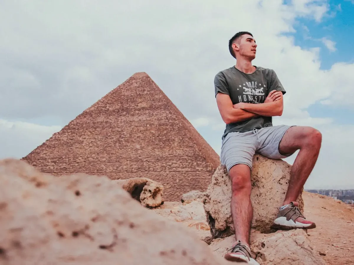 A traveler sitting in front of the Great Pyramid of Giza, showcasing iconic Egypt tourism and historical landmarks - Summer in Egypt 2026: The Honest Local Guide to June, July & August